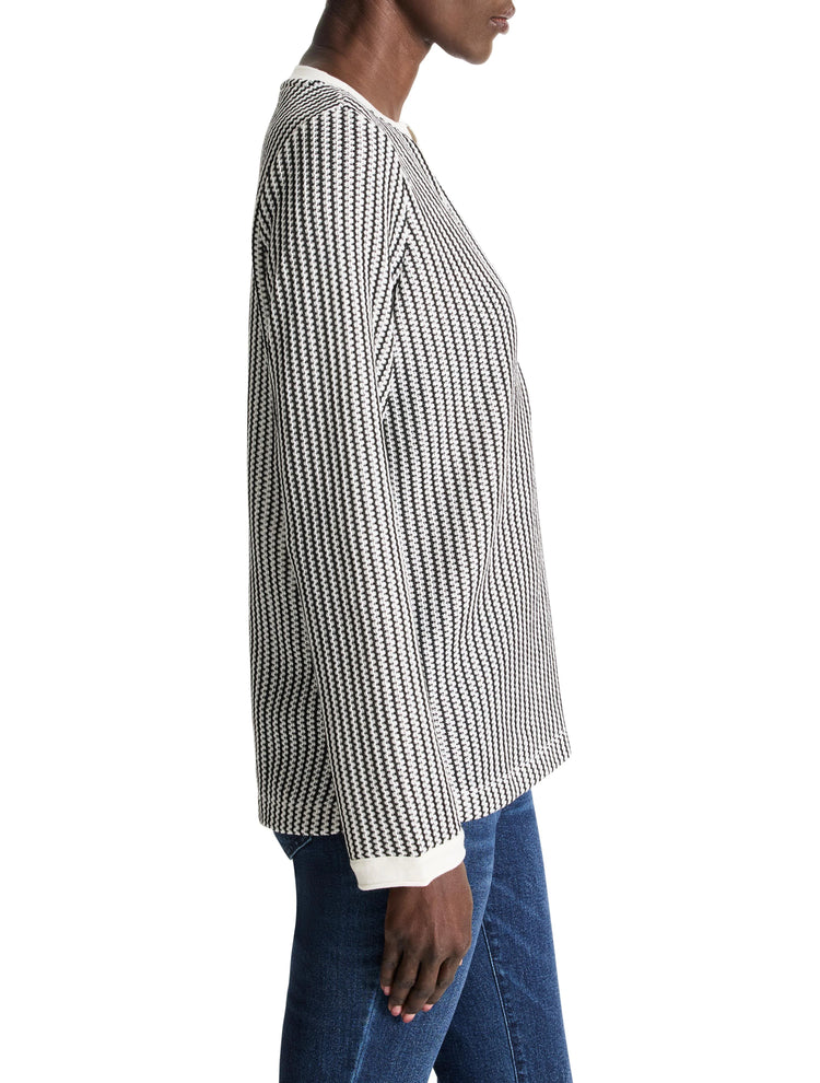 Off-white top with thin black vertical stripes, split neckline, long sleeves, and cream-colored cuffs.