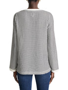 Black and white vertically striped knit top with split neck and cream-colored trim at neckline and cuffs.  Long sleeves.