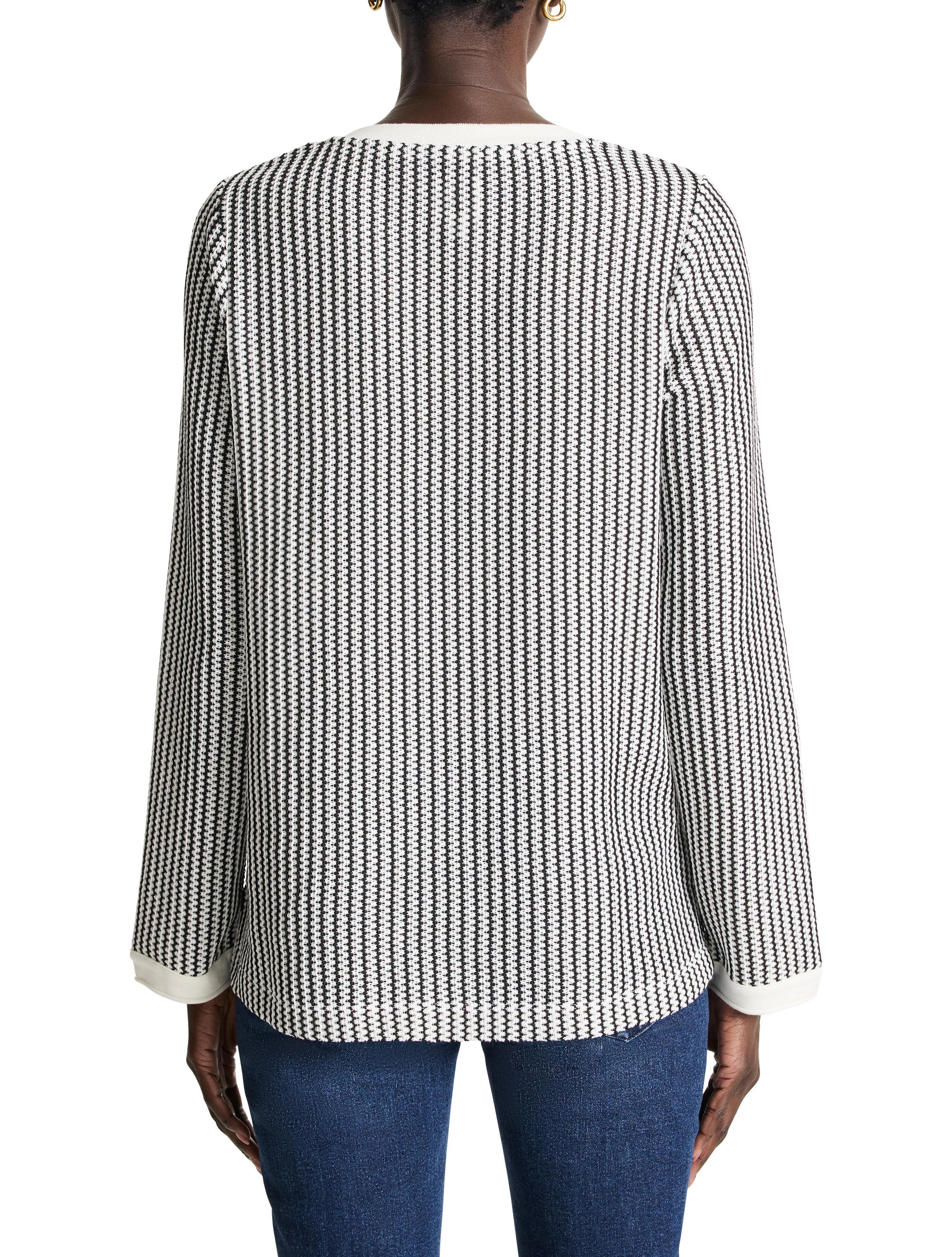 Black and white vertically striped knit top with split neck and cream-colored trim at neckline and cuffs.  Long sleeves.