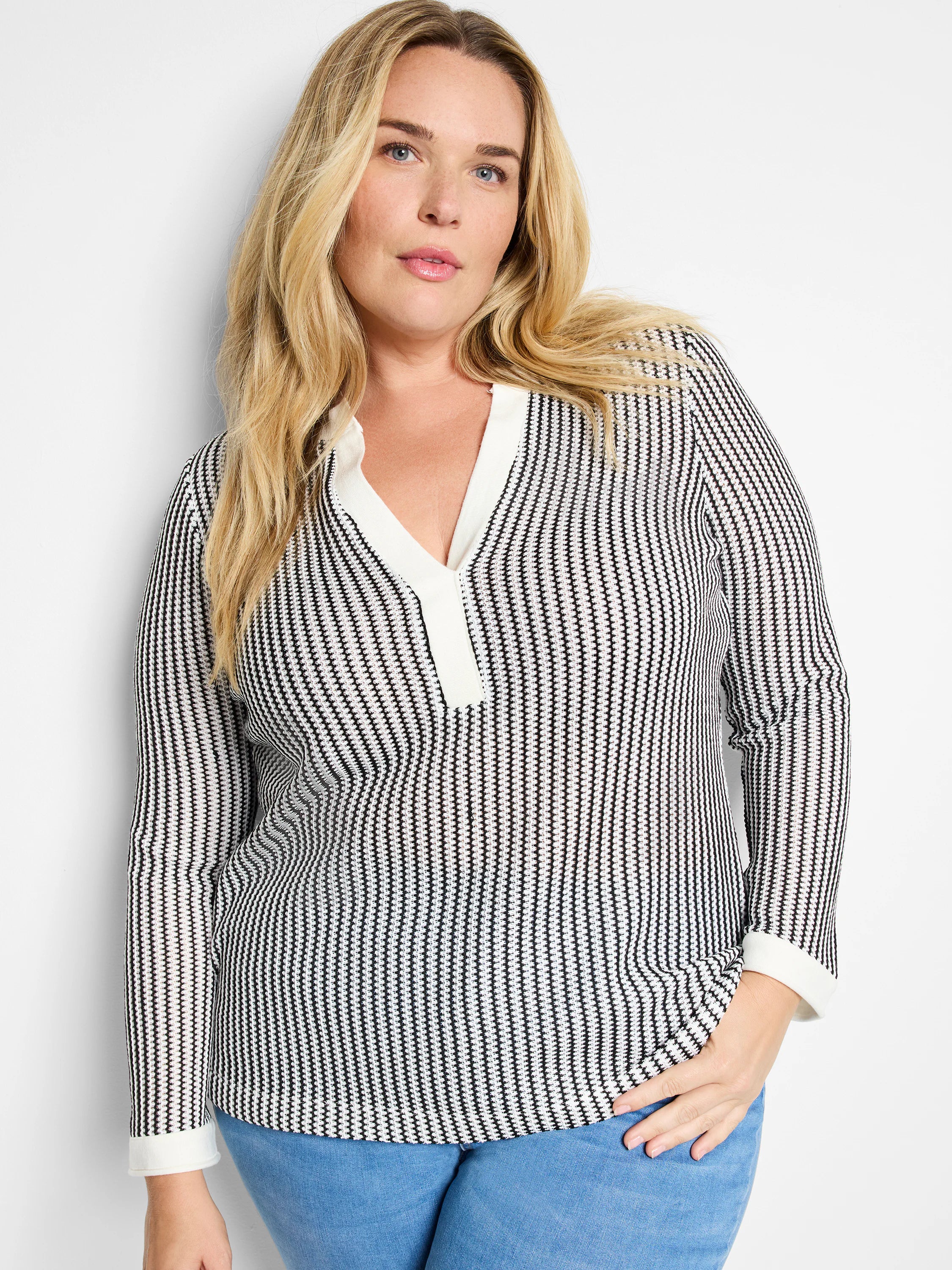 Black and white vertically striped long-sleeve top. Split neckline with off-white trim.