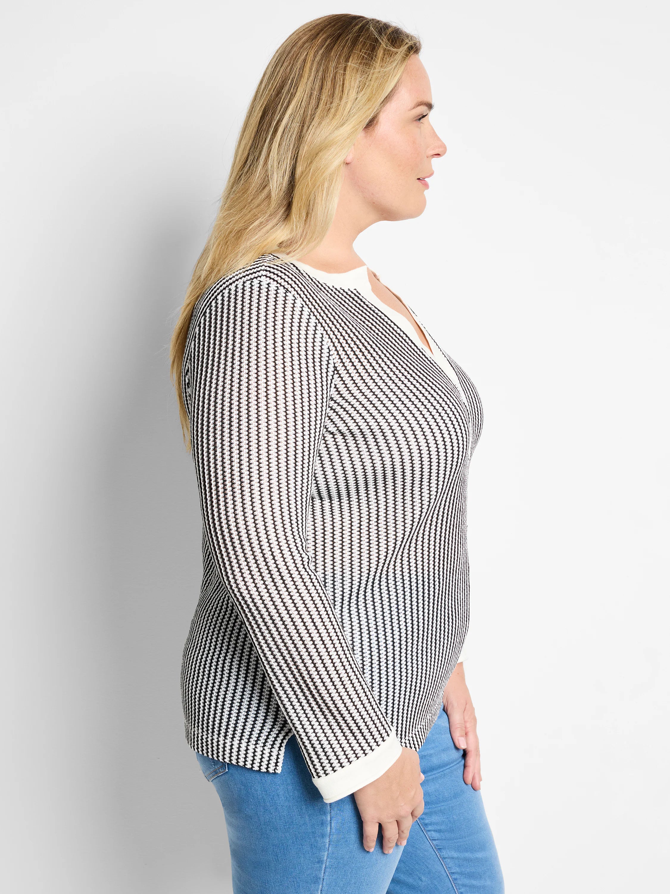 Black and white vertical striped knit top with split neckline and long sleeves.  Off-white trim at neckline and cuffs.