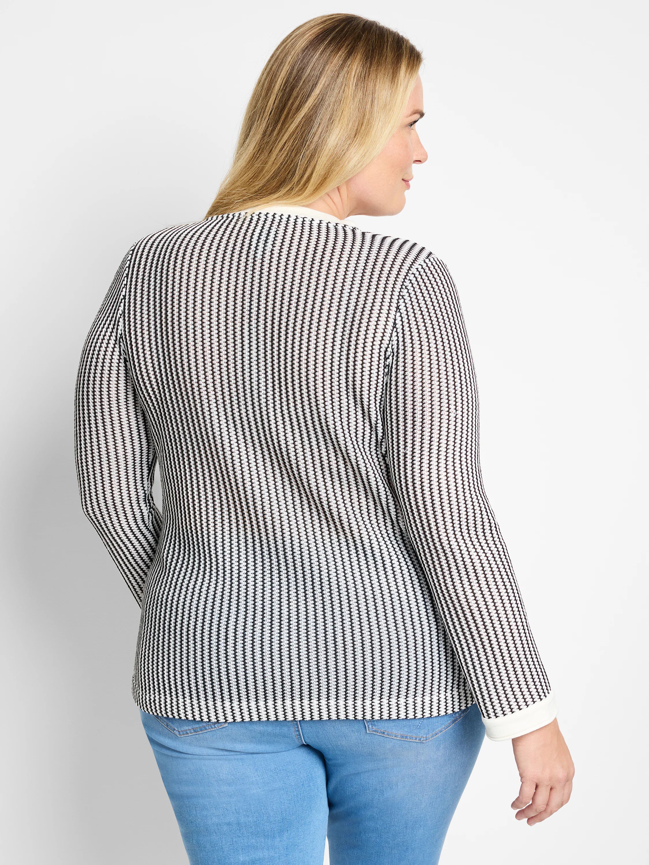 Black and white vertically striped knit top with long sleeves and a split neckline; off-white trim at cuffs.