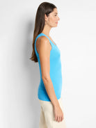 Bright blue ribbed knit scoop tank. Model in profile view, showing its snug fit.