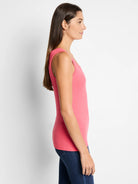 Fitted rose pink ribbed knit tank top with a scoop neck, worn by a woman in profile.