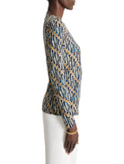 Long-sleeved, form-fitting top. Teal, beige, and white abstract batik print.  Side profile view.