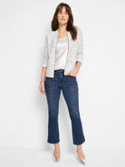 Off-white jacket with thin blue and gray stripes, zipper front, and small pockets.  Model also wears silver top and dark...