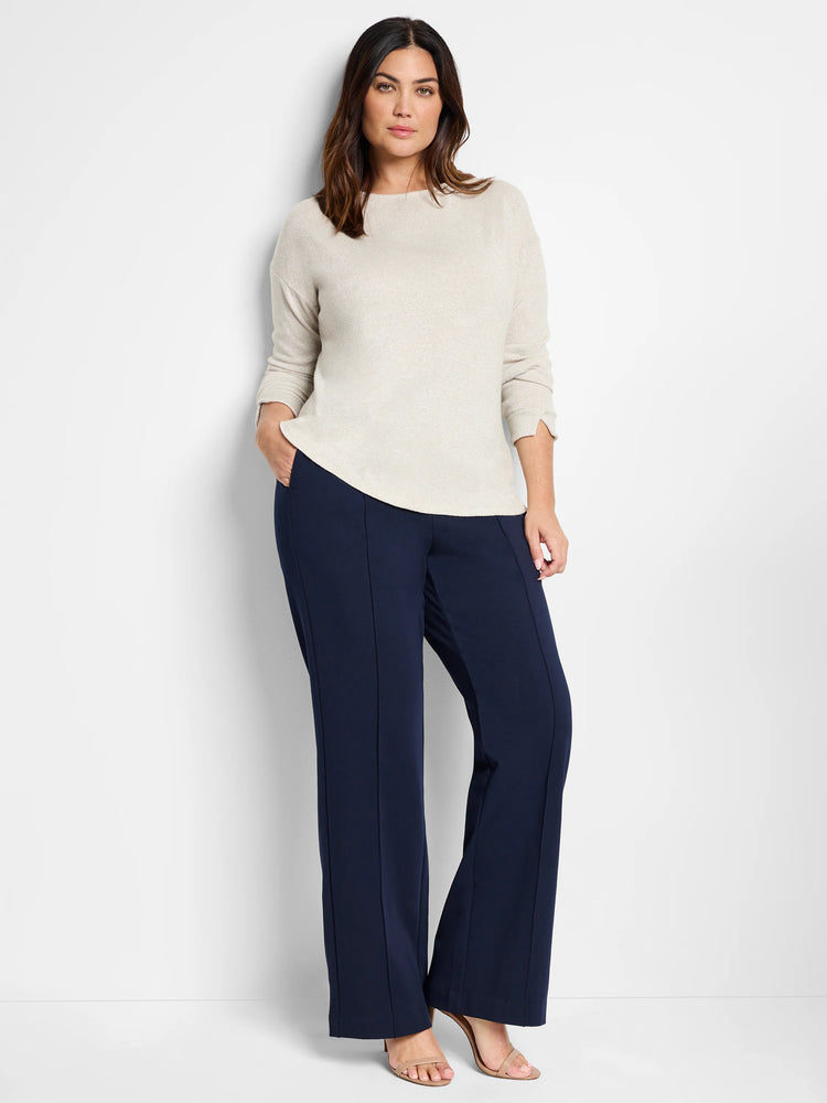 Off-white sparkly top, shown with dark navy blue pants.