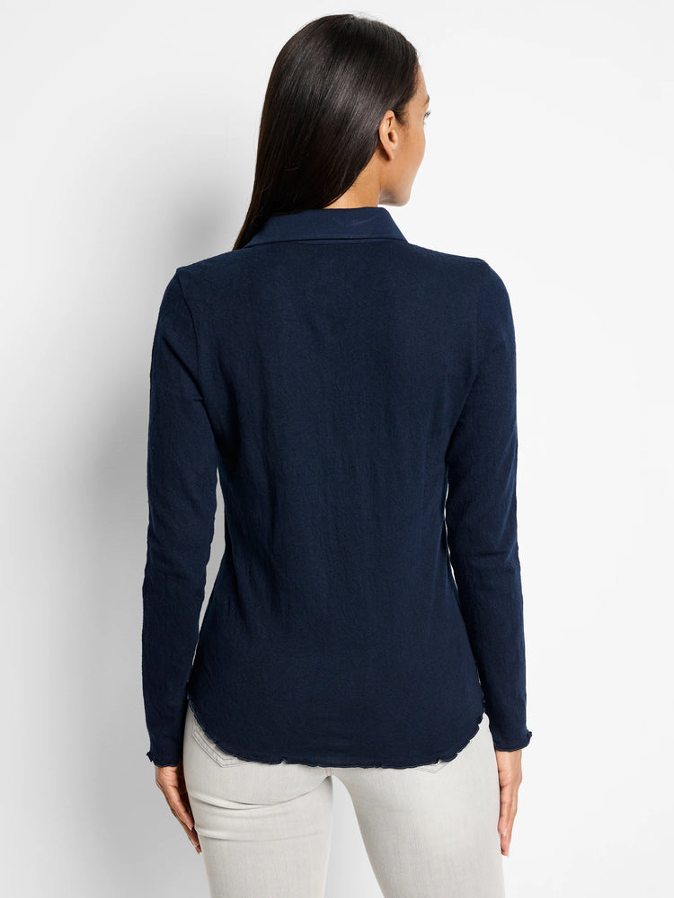 Navy lace knit collared top on model, back view. Features long sleeves, scalloped cuffs, and a scalloped hem.
