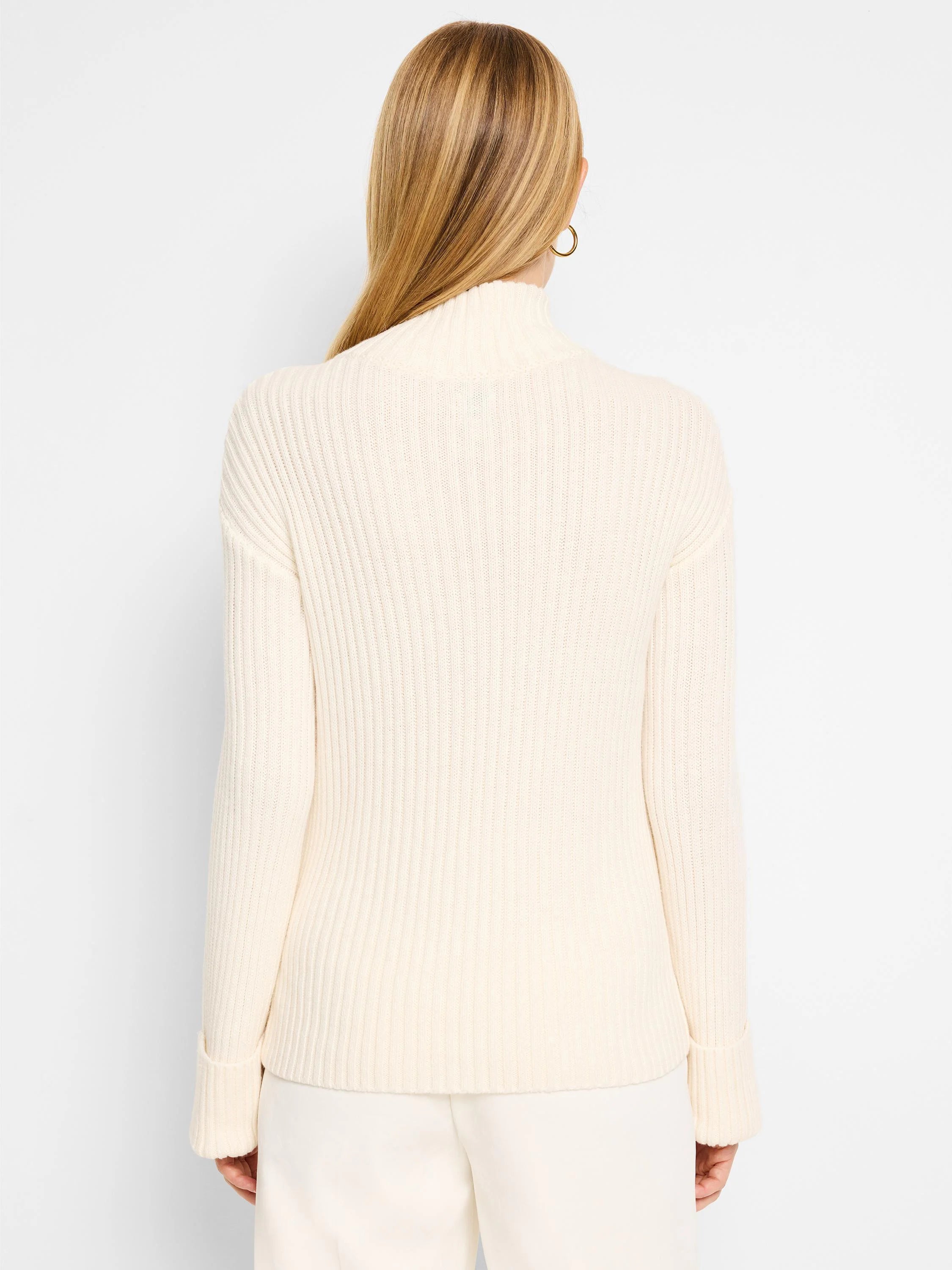 Off-white ribbed mock neck sweater.  Long sleeves with ribbed cuffs.  Vertical ribbing throughout.