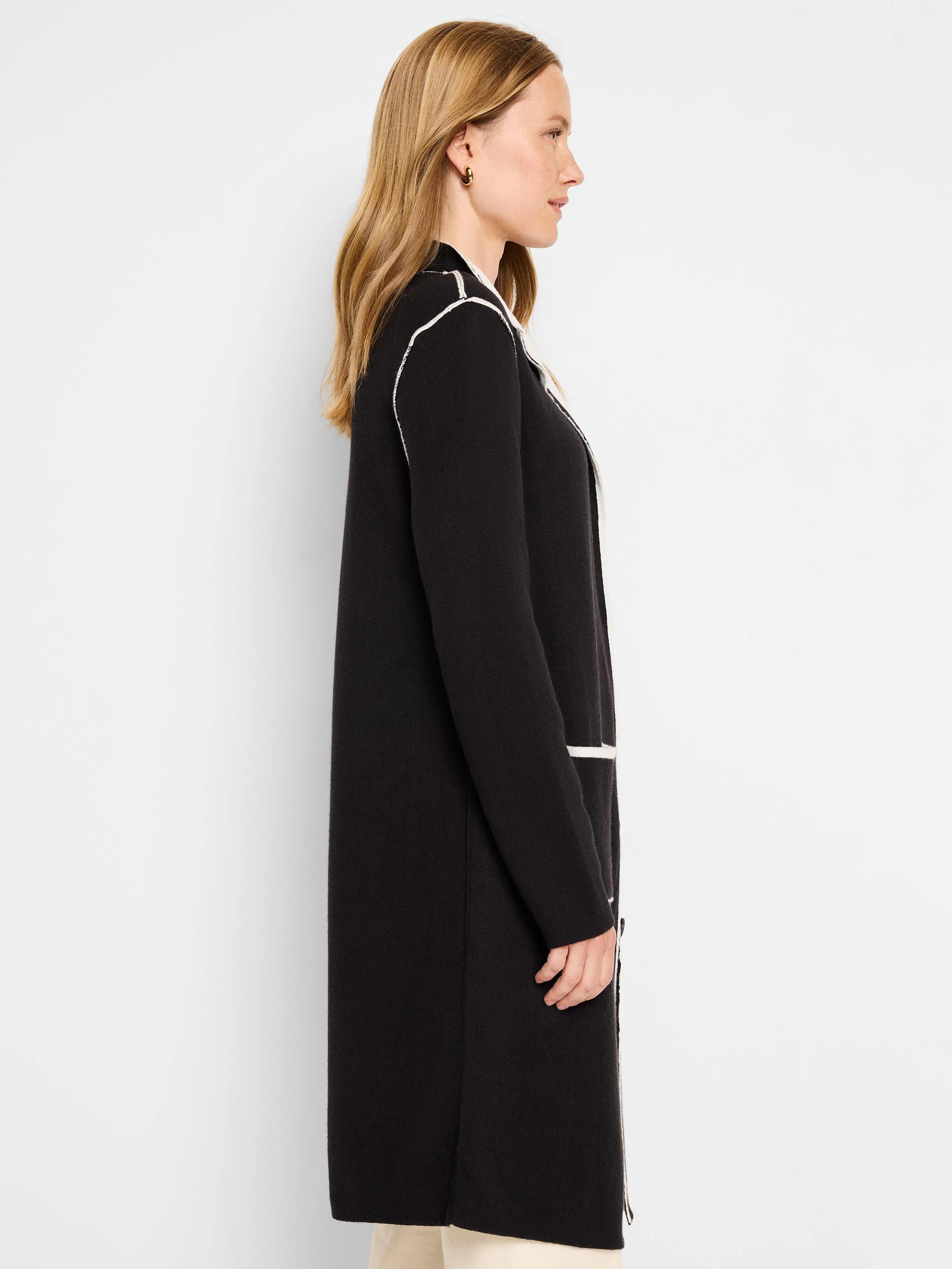 Long black open jacket with white piping along the collar, front edge, and horizontal pocket openings.