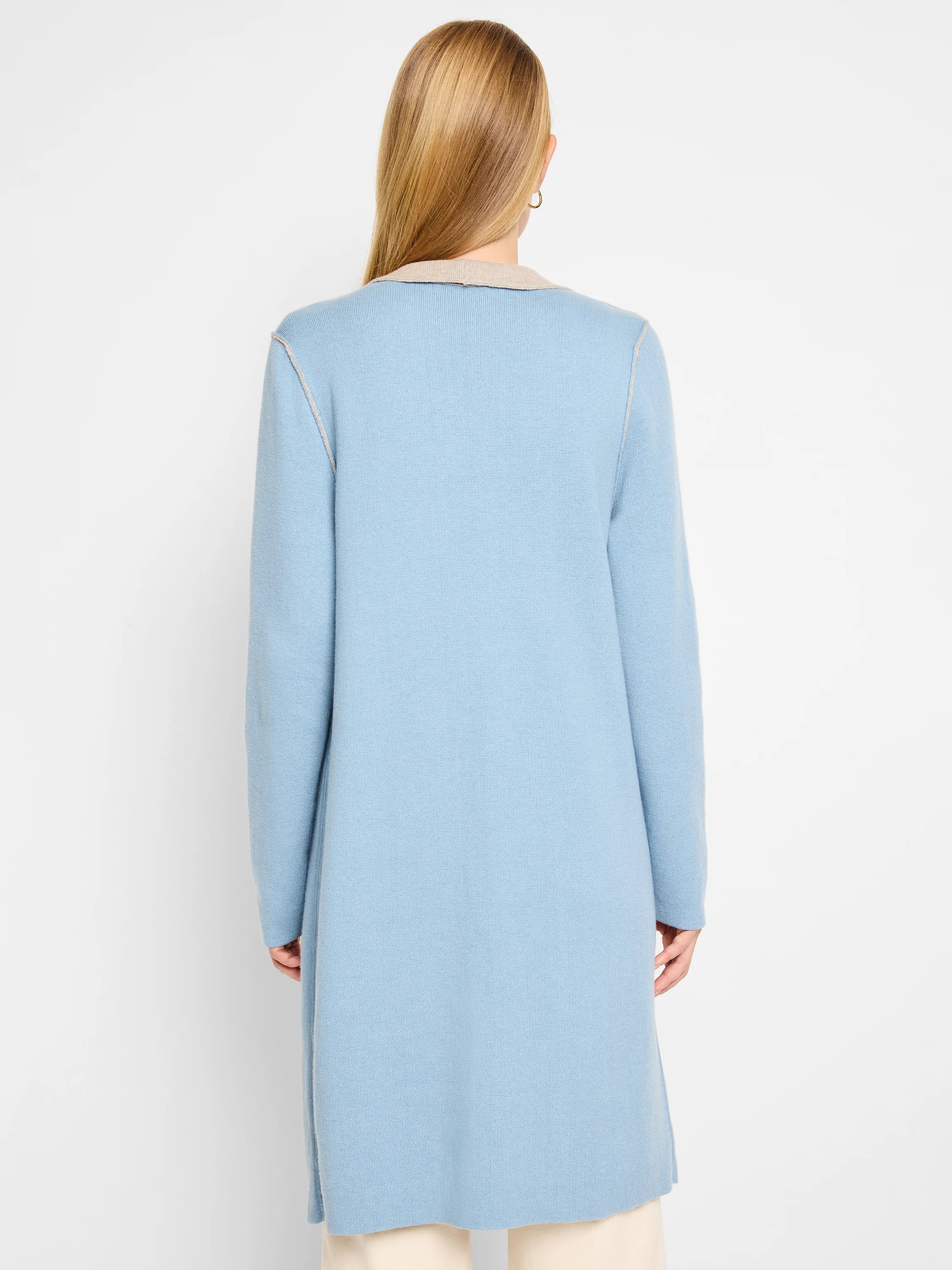Light blue reversible long knit jacket with tan collar and contrasting seam details, viewed from the back.