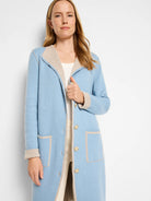 Long light blue reversible knit jacket with beige trim, button front, and patch pockets.