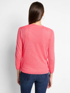 Vibrant pink lightweight knit cardigan with 3/4 sleeves and ribbed hem, viewed from back on model.