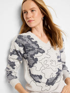 Light gray V-neck sweater with a dark gray/navy abstract pattern.