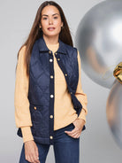 Navy blue quilted vest with gold buttons, knit trim, and a small pocket.