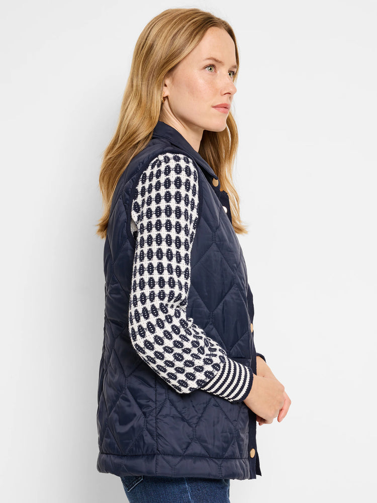 Navy blue quilted puffer vest.  Diamond quilting pattern.  Features a contrasting cream and navy knit trim. Gold buttons.
