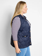 Navy blue quilted puffer vest with gold buttons and knit trim.  Side view.