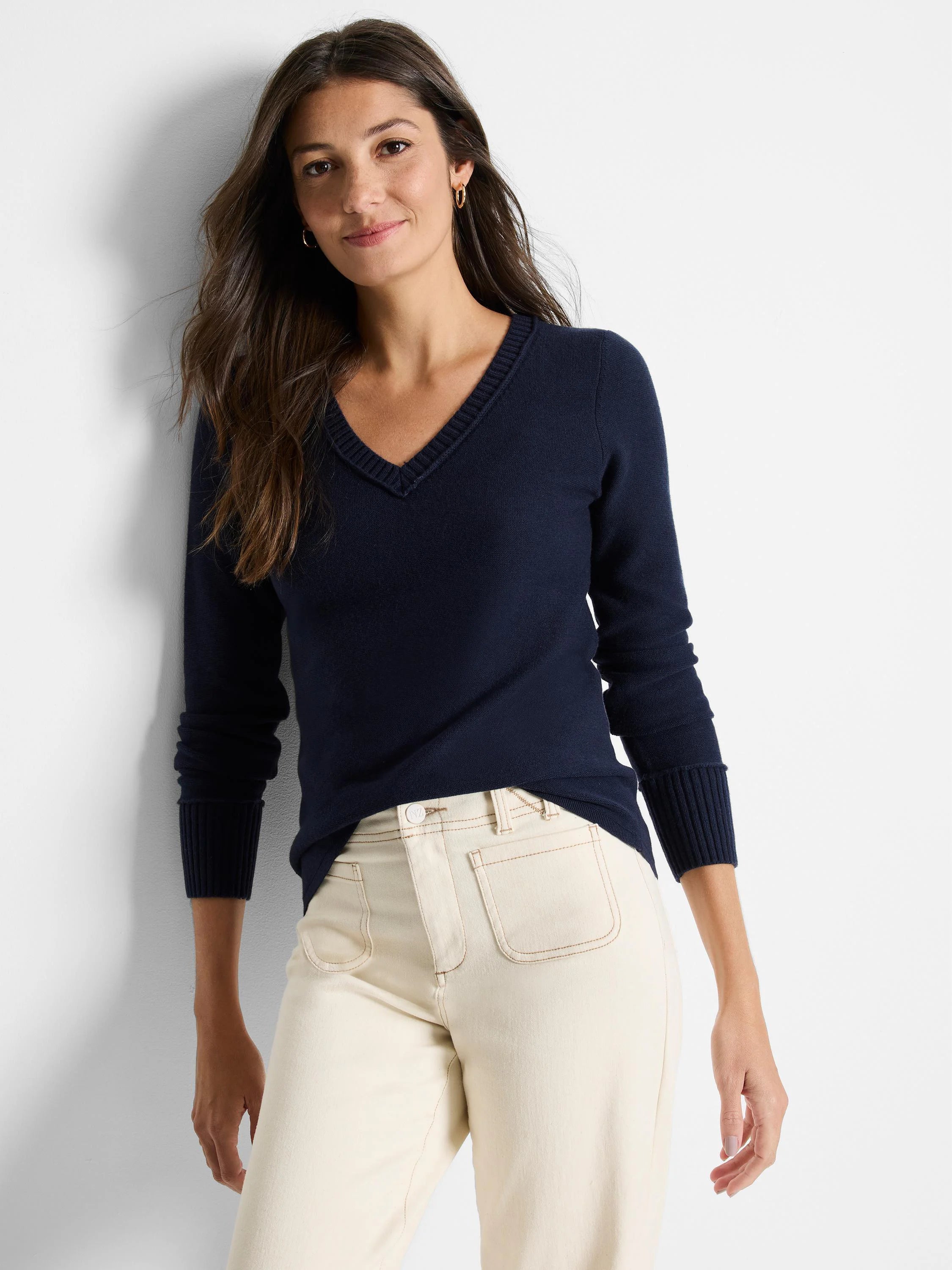 Navy V-neck sweater with ribbed trim on neckline, cuffs, and hem, worn by a woman with long dark hair.