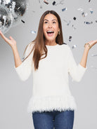 Off-white sweater with a white feather fringe hem.  Three-quarter sleeves.