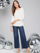 Off-white sweater with a white feather fringe at the hem.  Three-quarter sleeves.