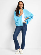 Light blue open cardigan, textured knit.  Model wears it over a white shirt and dark wash jeans.