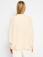 Cream-colored, oversized cardigan with a mock neck and long sleeves.  Knit texture. Rear view.