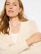 Off-white ribbed knit cardigan. Open front, long sleeves.