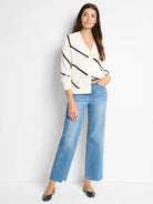Off-white cardigan with diagonal navy stripes, button front.
