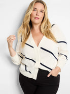 Off-white cardigan with navy blue diagonal stripes, V-neck, and button front.  Three-quarter sleeves.