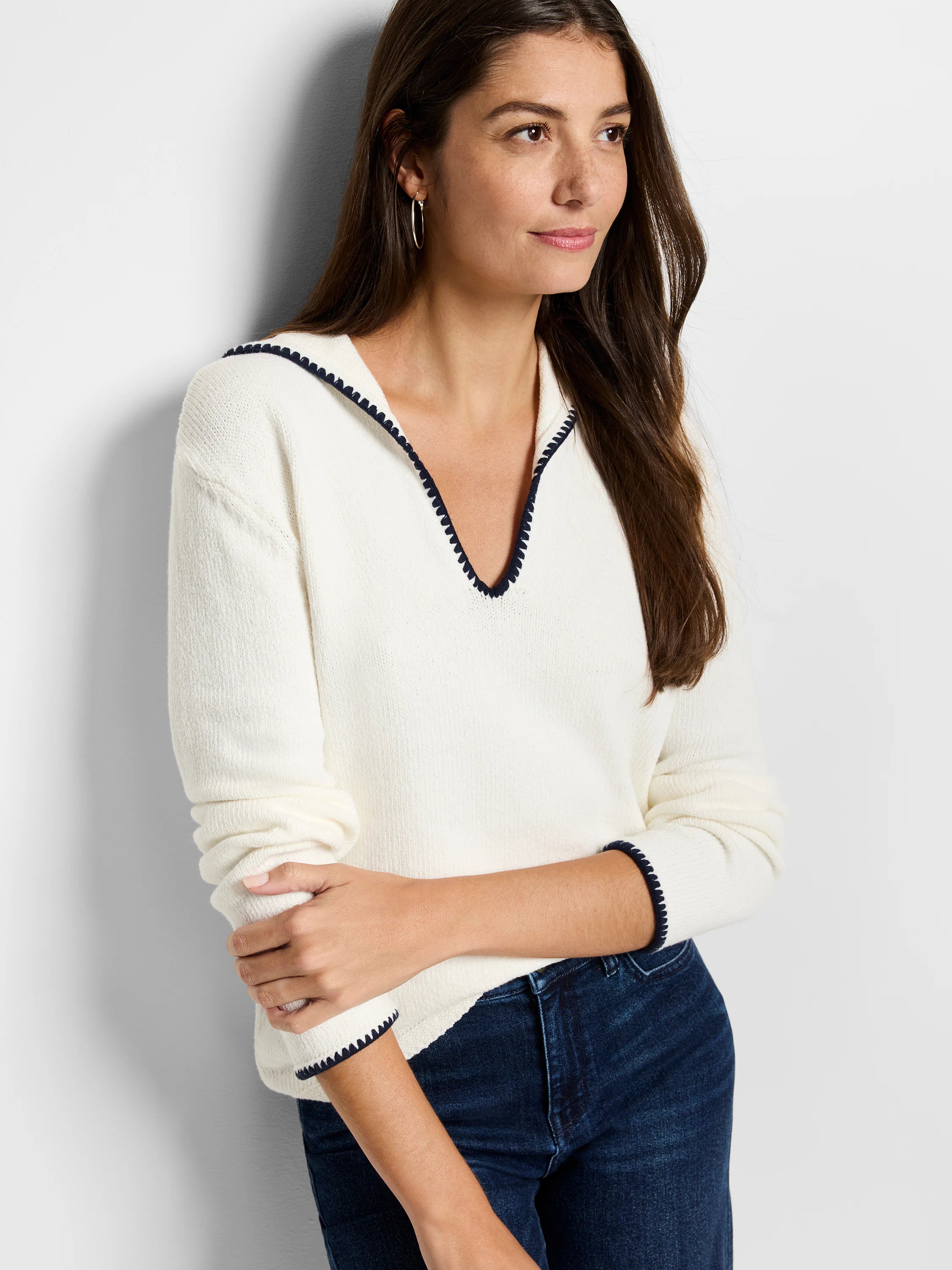 Cream-colored sweater with dark navy trim at neckline and cuffs.  Long sleeves, v-neck.