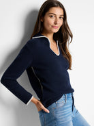 Navy blue long-sleeve sweater with off-white blanket stitch trim at neckline and sleeves.