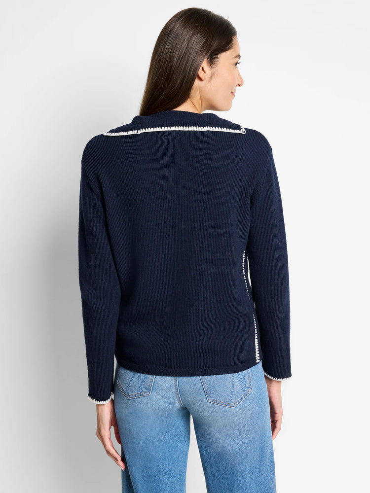 Here's alt text that meets the requirements:

"Navy blue ribbed sweater with off-white blanket stitch trim at neckline...
