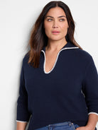 Navy blue sweater with off-white blanket stitch trim at neckline and sleeves.  Three-quarter sleeves. Ribbed knit.