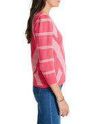 Pink sweater with white chevron pattern, three-quarter sleeves.