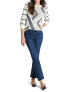 Cream-colored sweater with dark blue and white striped pattern.  Three-quarter sleeves. Geometric design.