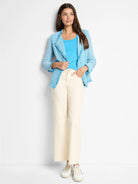 Light blue textured knit jacket with fringe trim on lapels, front, hem, and cuffs.