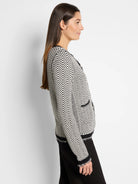 Black and off-white patterned sweater jacket, button front, frayed edges.