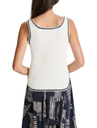Off-white ribbed tank top with navy trim.  The bottom hem shows a dark navy and beige print.