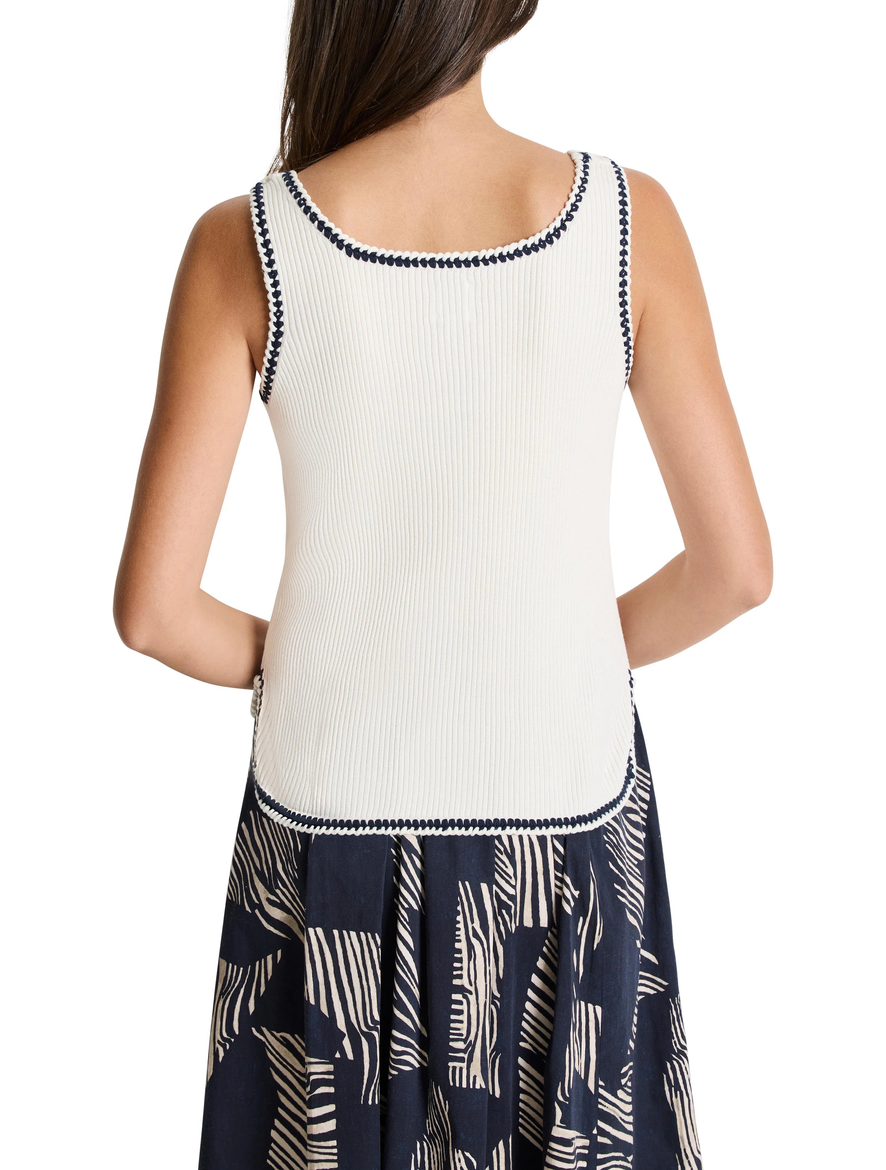 Off-white ribbed tank top with navy trim.  The bottom hem shows a dark navy and beige print.