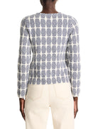 Cream-colored knit jacket with a dark-blue geometric pattern.  Long sleeves.