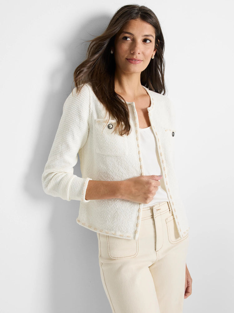 Off-white knit jacket with beige trim and small buttons.  Close-fitting, textured fabric.