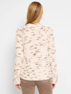 Cream-colored sweater with a subtle taupe speckled pattern, long sleeves, and a relaxed fit.