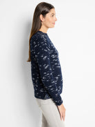 Navy blue sweater with a white speckled pattern, long sleeves, and a crew neck.