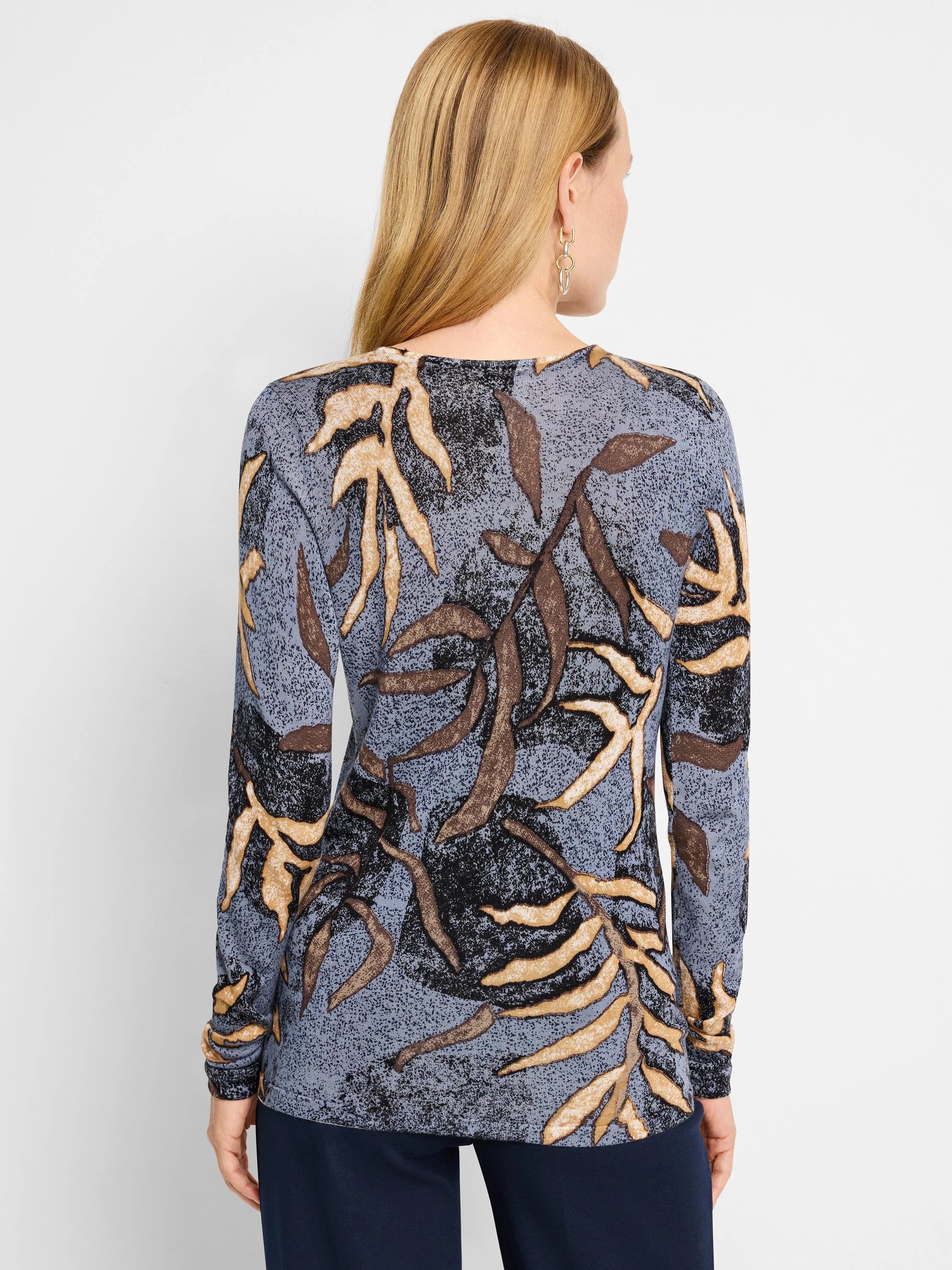 Long-sleeved blue sweater with tan and brown leaf pattern.
