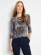 Blue long-sleeve sweater with brown and beige fern pattern.