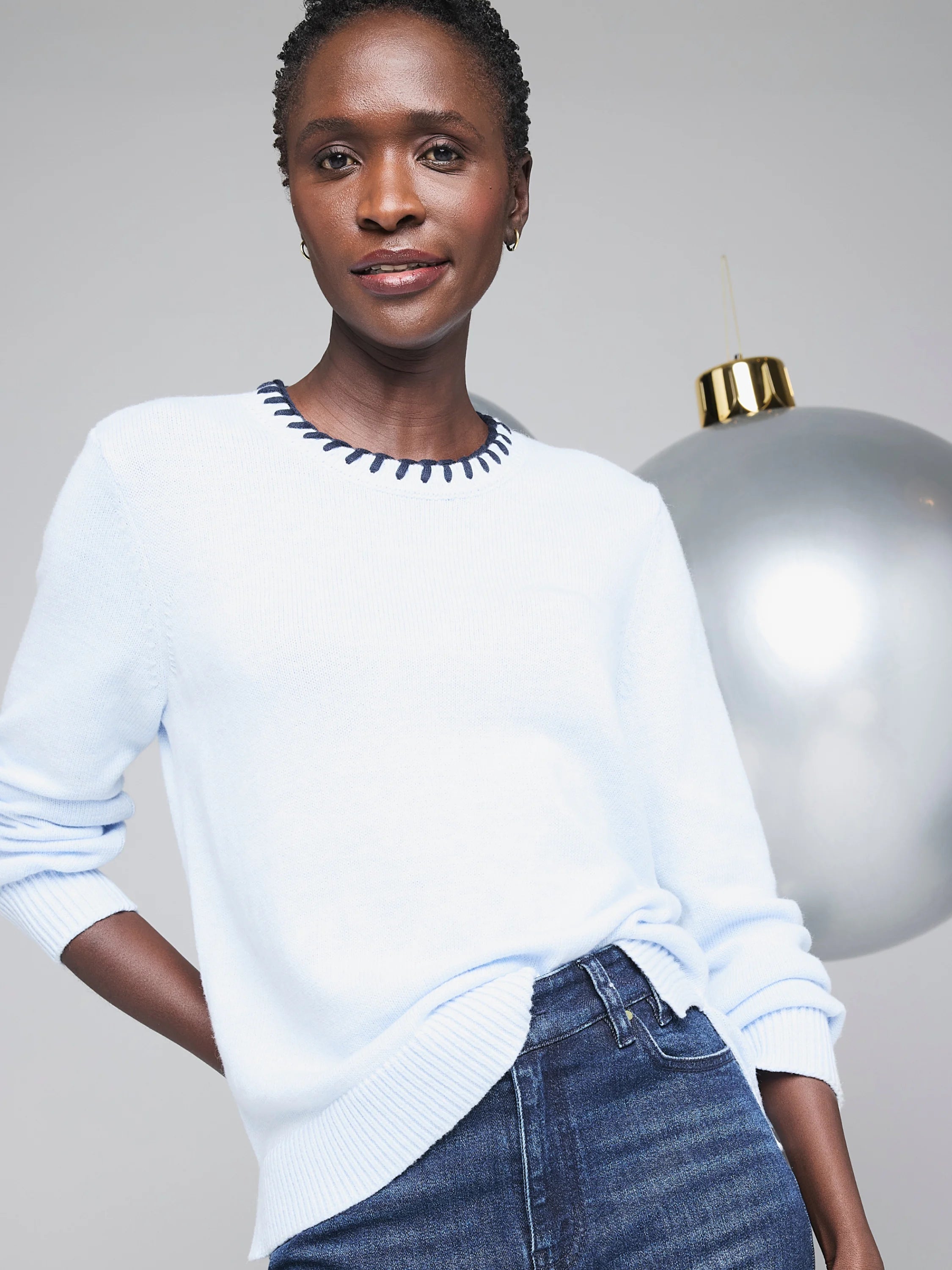 Light blue cotton cashmere sweater with a navy blue blanket stitch neckline.