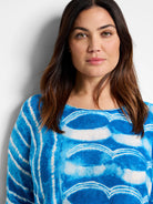 Blue and white tie-dye pattern on a boatneck sweater.  Horizontal stripes of varying shades of blue and white.