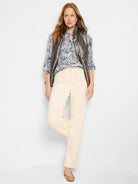 Gunmetal gray vest over a blue, brown, and white patterned henley.  Beige pants.