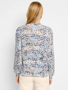 Cream henley sweater with blue and brown abstract spots.  Long sleeves, ribbed cuffs and hem.