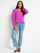 Fuchsia V-neck cashmere blend sweater. Long sleeves.  Model shown wearing light wash jeans & dark flats.